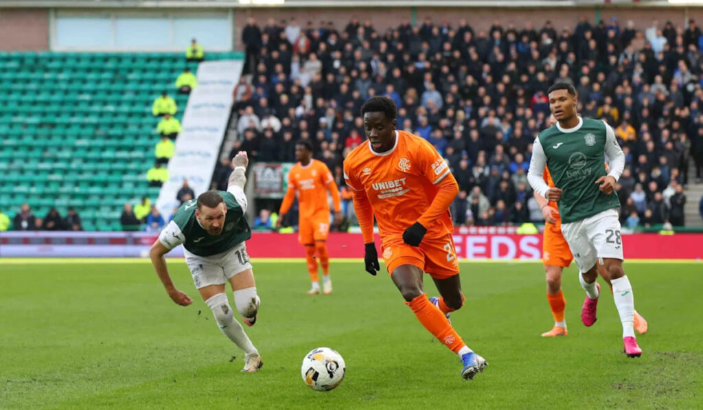 Gassama running down the pitch with the ball at his feet while playing against Hibernian